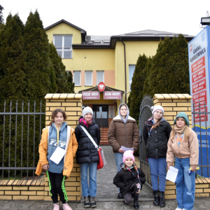 Grupa uczestników gry terenowej, stojąca przed budynkiem Urzędu Gminy w Kąkolewnicy.