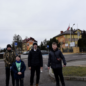 Grupa uczestników gry terenowej, stojąca w pobliżu Urzędu Gminy w Kąkolewnicy.